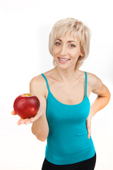 blond girl holding apple and smiling.