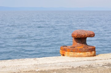 Old, rusty mooring bollard on port of Podgora, Croatia