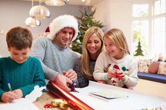 Family Wrapping Christmas Gifts At Home