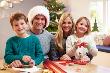 Family Wrapping Christmas Gifts At Home