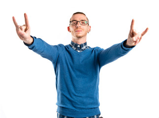 Fototapeta premium Young man doing the horn sign over white background