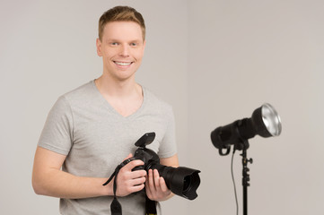 handsome young man holding camera.