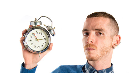 Redhead man holding an antique clock over white background