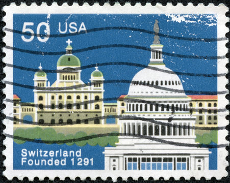 stamp shows Federal Palace, Bern and Capitol, Washington