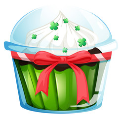 A cupcake container with a green cupcake and a pink ribbon