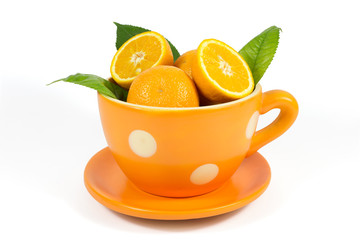 Orange fruit with green leaves in ceramic bowl isolated