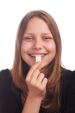 teen girl eating bubblegum on white background