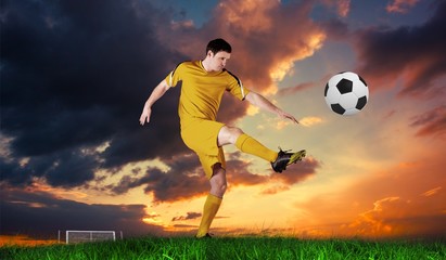 Composite image of football player in yellow kicking