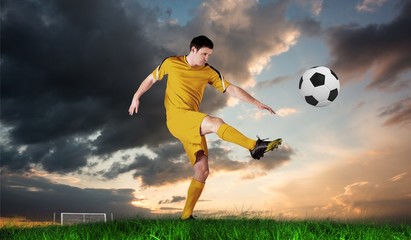 Composite image of football player in yellow kicking