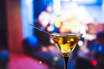 glass with martini and green olives