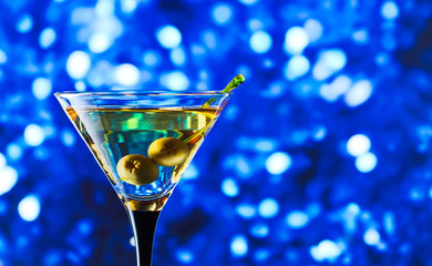 glass with martini and green olives