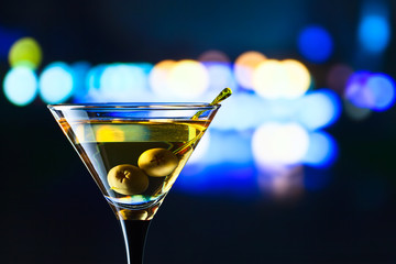 glass with martini and green olives