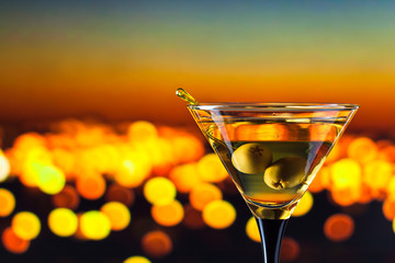 glass with martini and green olives