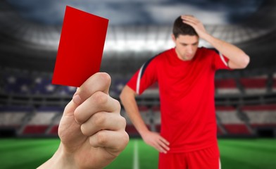 Composite image of hand holding up red card
