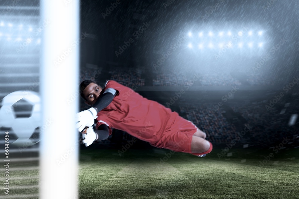Poster Composite image of goalkeeper in red making a save