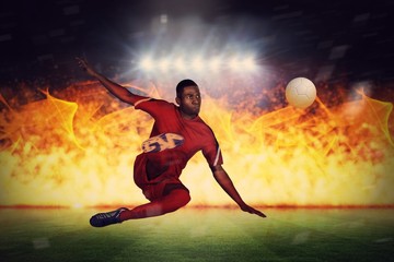 Composite image of football player in red kicking