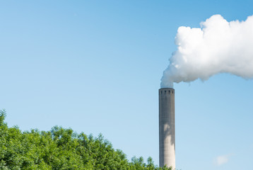 Smoking chimney against a bright blue sky