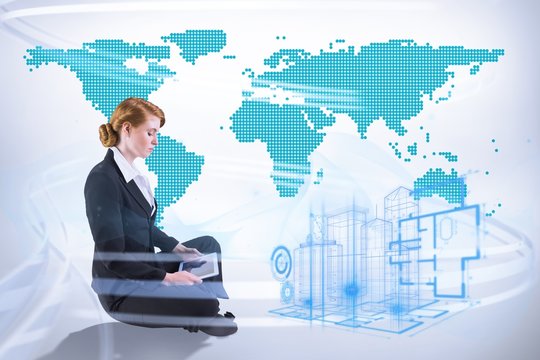 Composite image of redhead businesswoman using her tablet pc