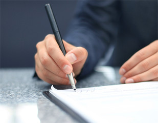 Businesswoman sitting at office desk signing a contract