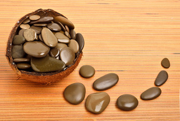 Fototapeta na wymiar Pebble stones for spa in coconut shell
