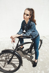 Fototapeta na wymiar Young woman hipster standing with black bike