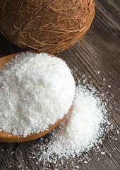 Coconut and grounded coconut flakes on wood