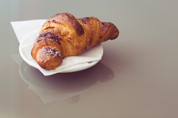 fresh croissants on a plate, vintage tone.