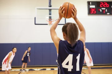 Muurstickers Female High School Basketball Player Shooting Basket © Monkey Business