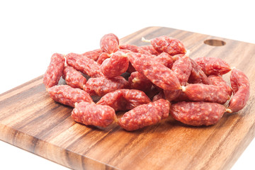 A heap of mini Salamis on wooden board