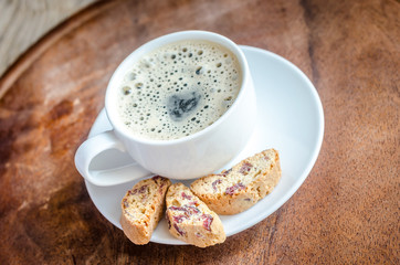 A cup of coffee with biscotti