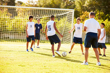 Members Of Male High School Soccer Playing Match