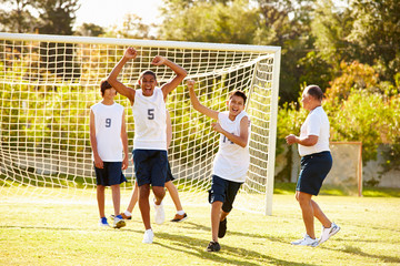 Player Scoring Goal In High School Soccer Match