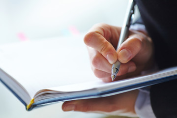 Female hand writing in notebook