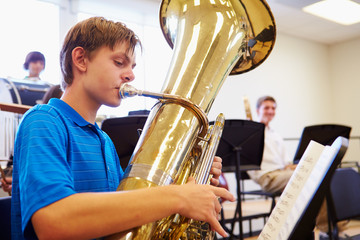 Male Pupil Playing Tuba In High School Orchestra - obrazy, fototapety, plakaty