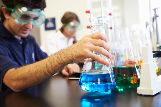 Pupils Carrying Out Experiment In Science Class