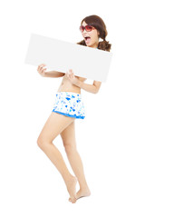 young girl wearing a swimwear  and holding a white board