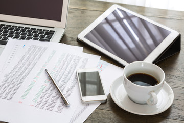 Obraz na płótnie Canvas Laptop, tablet , smartphone and coffee cup with financial docume