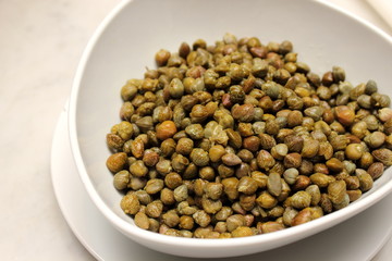 Marinated capers on a white plate