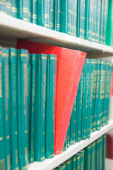 Book in a bookshelf standing out at university library