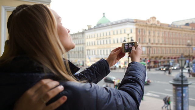 Loving couple having fun making photos of themselves with cell