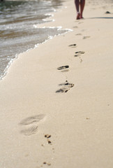 Legs on a beach and footprints