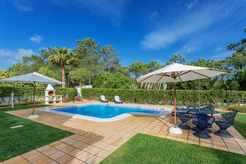 Adorable modern swimming pool with decorative furniture.