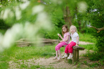Naklejka na ściany i meble Two cute little sisters outdoors