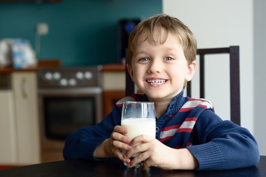 smiling  boy holds a healthy glass of fresh milk