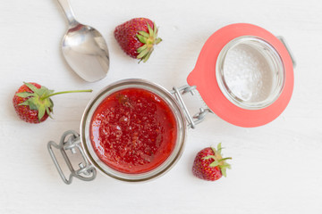 Erdbeermarmelade in einem Einmachglas auf Holz