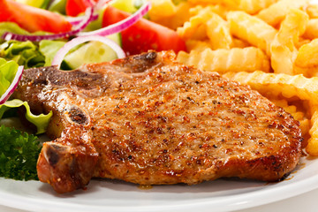 Pork chop, French fries and vegetables