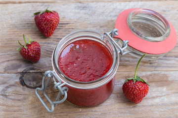 Erdbeermarmelade in einem Einmachglas auf Holz