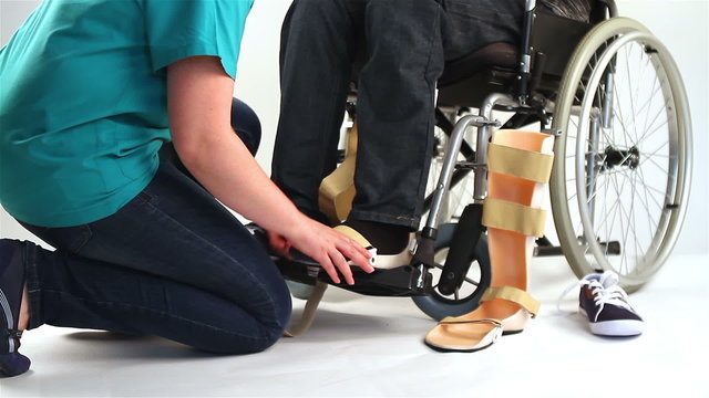 Orthopedist puts orthosis to patient with disabilities