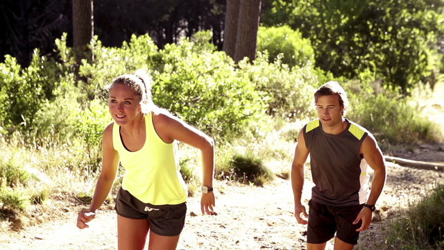 Couple jogging on forrest path in slow motion