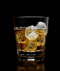 glass of whiskey with ice on a black background